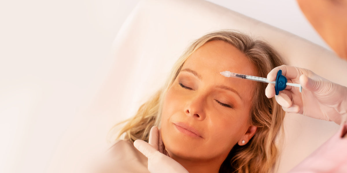 A patient receiving a facial treatment with a blue NavaClick syringe